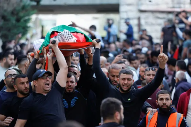مشيعون يحملون جثمان أحد الفلسطينيين اللذين قتلهما جنود إسرائيليون في رام الله بالضفة الغربية المحتلة قبل أيام