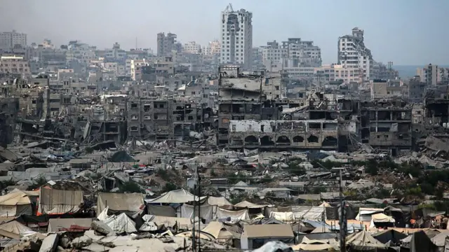 An image of tents used as temporary shelters by displaced Palestinians are set up near war-damaged buildings in Gaza City 