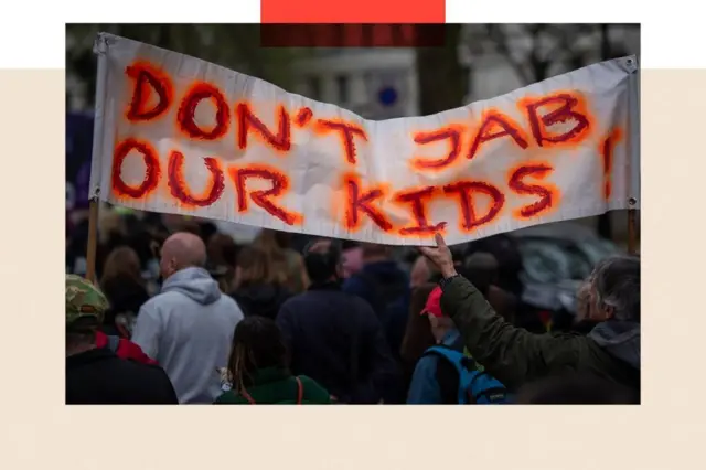 "எங்கள் குழந்தைகளுக்குத் தடுப்பூசி போடாதீர்கள்" என்று ஒரு பதாகையை ஏந்திய போராட்டக்காரர்கள்