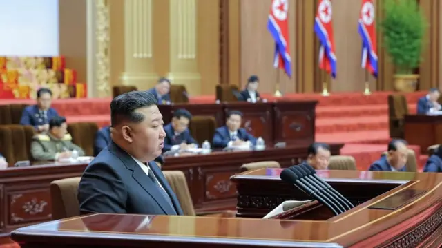 Hoton Shugaba Kim na jawabi a wani zauren taro.
