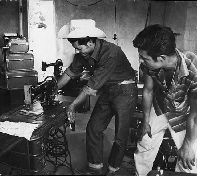 Braceros empacando una máquina de coser de pedal