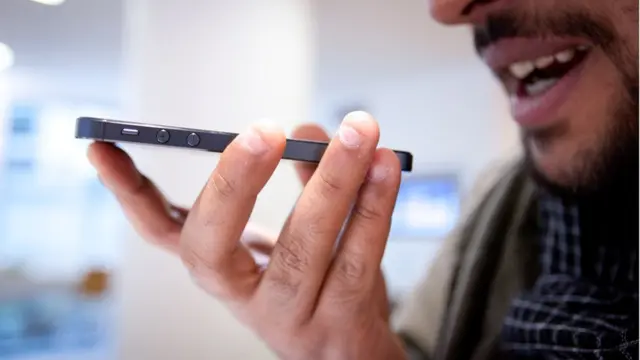 Hombre hablándole a un celular