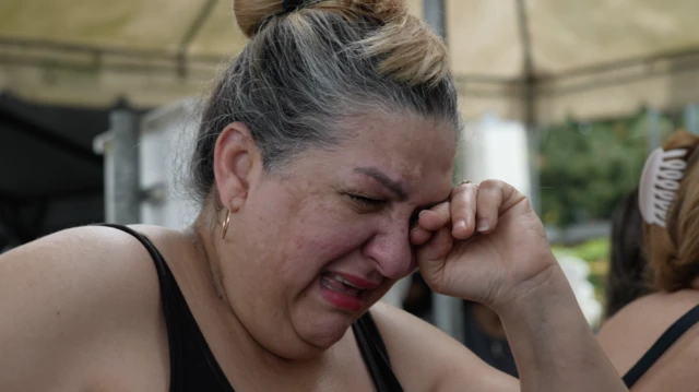 Una mujer se lleva la mano a su cara y llora desconsoladamente