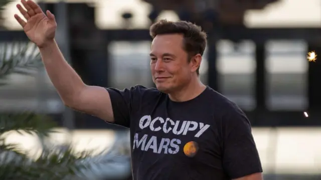 馬斯克身穿印有「佔領火星」(Occupy Mars)字樣的上衣,在舞台上行走