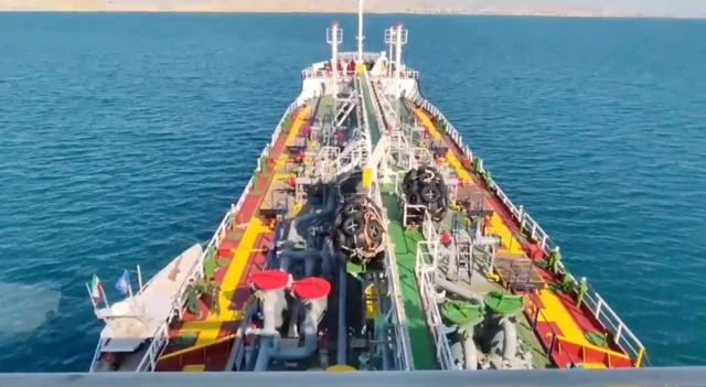 تصویری از ویدیویی که خبرگزاری میزان از توقیف نفتکش منتشر کرده که یک قایق تندروی سپاه را پهلوی آن نشان می‌دهد.