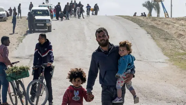 فلسطينيون نازحون داخليًا يسيرون بعد أن أمر الجيش الإسرائيلي سكان منطقة حمد في خان يونس بمغادرة منازلهم والتوجه نحو رفح