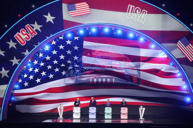 ফিফা ড্র অনুষ্ঠানের সময় ফিফার প্রেসিডেন্ট জিয়ানি ইনফান্তিনোর সাথে মার্কিন প্রেসিডেন্ট ডোনাল্ড ট্রাম্প, মেক্সিকোর প্রেসিডেন্ট ক্লডিয়া সেইনবম, কানাডার প্রধানমন্ত্রী মার্ক কার্নি