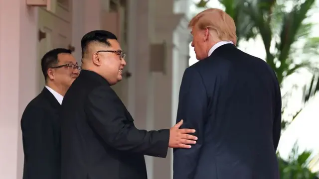Bwana Kim na Bwana Trump mu nama yabo ya mbere yabereye i Singapour - bandika amateka yo kuba abategetsi ba mbere b'ibihugu byombi bakoranye inama bakiri ku butegetsi