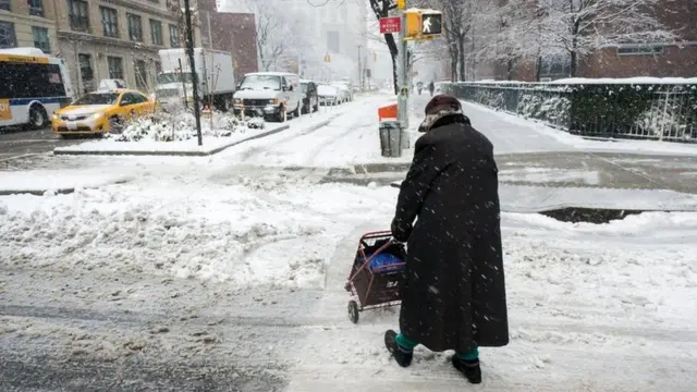 Idosa atravessa a ruasite da loteria esportivameio a neve