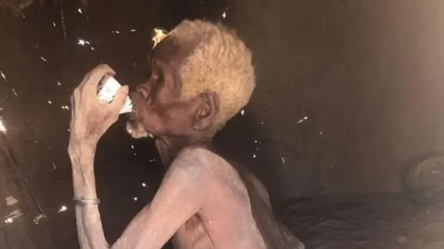 Mzee akinywa maziwa ya paketi ya msaada eneo la Turkana