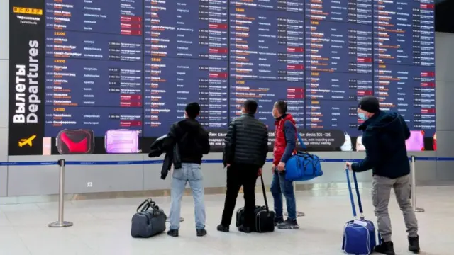 Пассажиры у информационной стойки в аэропорту