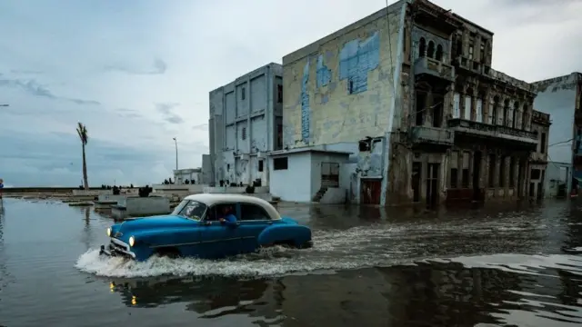 Carro passando por rua inundadabonuskodebet365Cuba