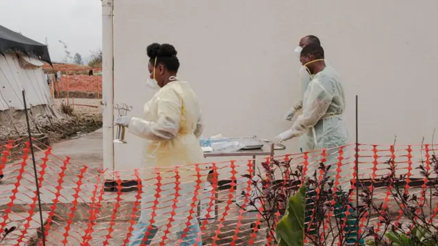 Abakozi batatu bo kwa muganga barimo kugenda imbere mu kigo cyo kuvuriramo ubushita bw'inkende (Mpox) cyo ku bitaro bya kaminuza bya Kamenge, i Bujumbura mu Burundi, ku itariki ya 22 Kanama (8) mu 2024.