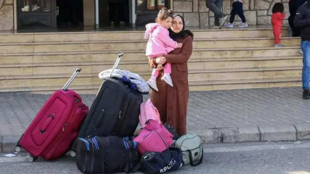 बच्ची के साथ खड़ी सीरियाई महिला