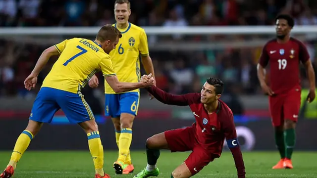 Le joueur suédois Sebastian Larsson aide Cristiano Ronaldo du Portugal à se relever, lors du match amical marquant le rebaptisation de l'aéroport de Madère