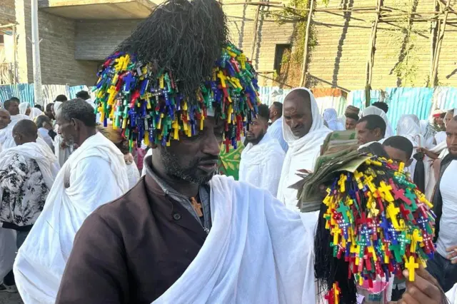 በበዓሉ ላይ በደማቅ ቀለማት የተሠሩ መስቀሎችን የሚሸጥ ነጋዴ