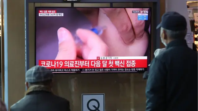 백신접종 계획이 발표된 28일 서울역 대합실에서 시민들이 관련 뉴스를 시청하고 있다