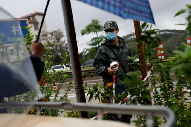 दुर्घटनास्थलतिर जाने एउटा गाउँमा सुरक्षाकर्मीहरू