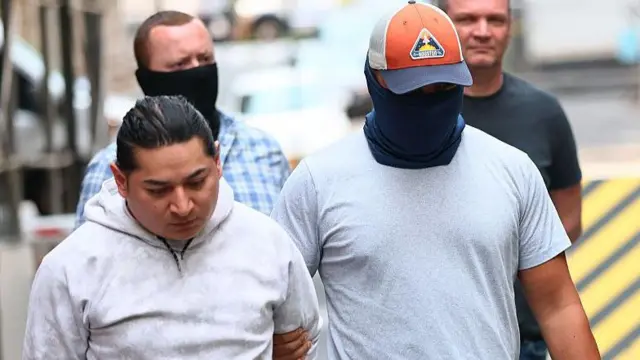 Agentes enmascarados detienen a un migrante en Nueva York.