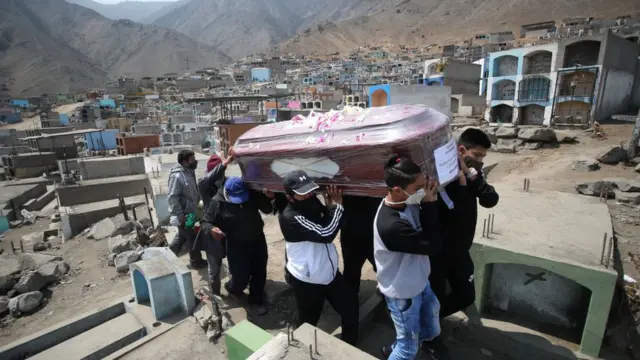 Personas cargando una urna.