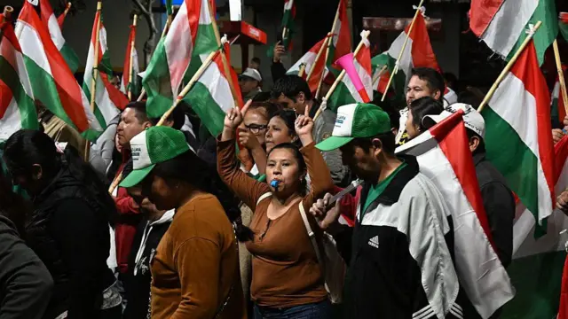 Bolivianos con banderas alusivas al PDC celebrando durante la noche