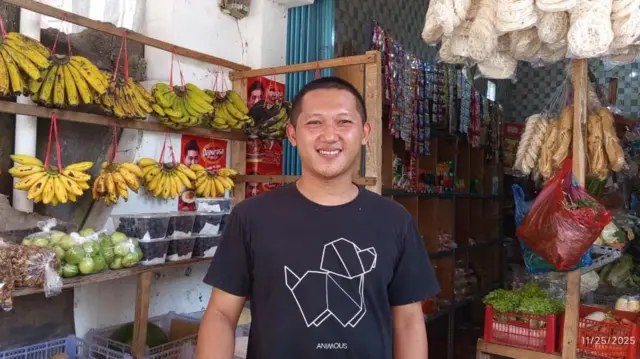 Asep Kurniawan, pengusaha warung kebutuhan pokok yang jaraknya 30 km dari dapur makan bergizi gratis mengaku pendapatannya menurun.