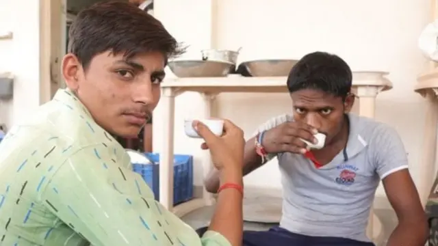 લીલા રંગના શર્ટમાં પ્રવાસી મજૂર સુમીત કઠેરીયા