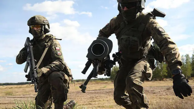 Солдати біжать полем з автоматами 