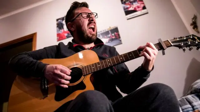 Мужчина поет и играет на гитаре