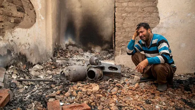 कश्मीर में सीमा के पास एक घर पर हुई गोलाबारी के बाद रोते हुए एक शख़्स