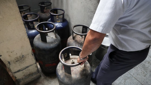 Мушкарац помера боце са плином 