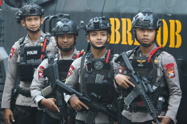 Sejumlah personel Detasemen Gegana Satbrimob Polda Jawa Timur membawa senjata saat apel pasukan pengamanan Hari Buruh di Jalan Pahlawan, Surabaya, Jawa Timur, Jumat (1/05).