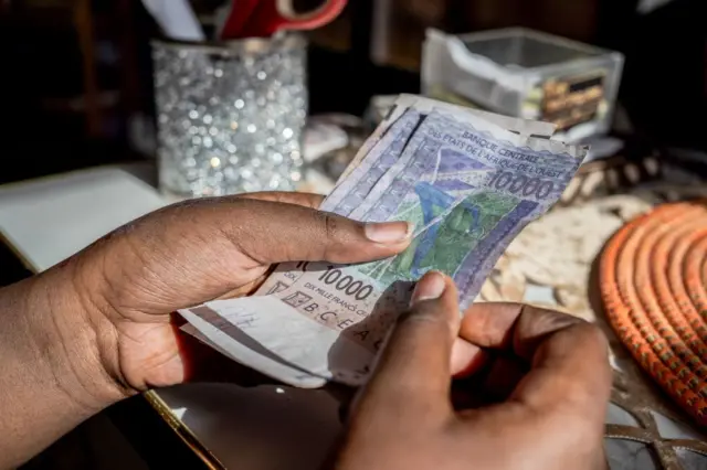 Un commerçant compte les billets de franc ouest-africain (CFA) à Dakar, au Sénégal, le lundi 3 juin 2024.
