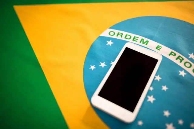 Celular em cima da bandeira do Brasil