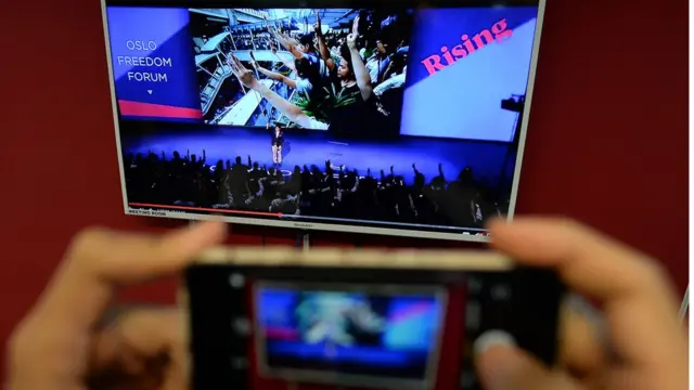 นายเนติวิทย์เรียกร้องให้ผู้ร่วมงานร่วมชูสามนิ้ว ซึ่งเขากล่าวติดตลกว่า ชูที่งานไม่ถูกควบคุมตัว เหมือนในไทย