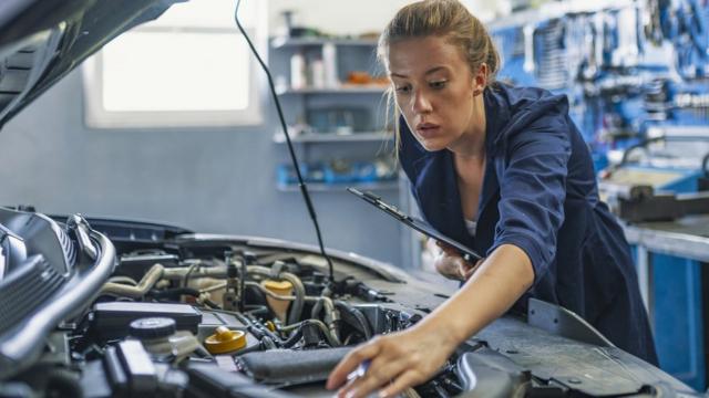 Woman looking at a car engine