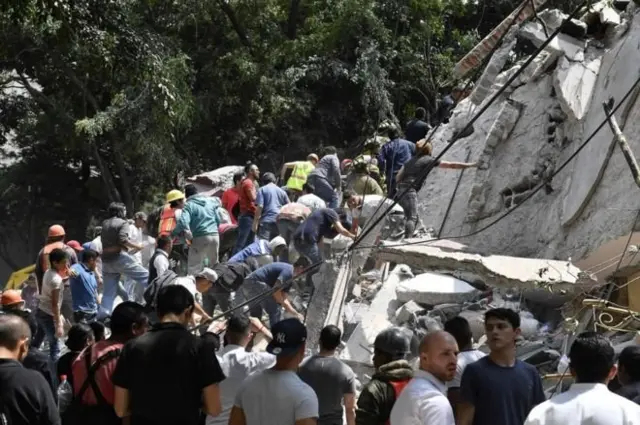 Some buildings collapse and people dey try to climb over di building to go look for who survivor.