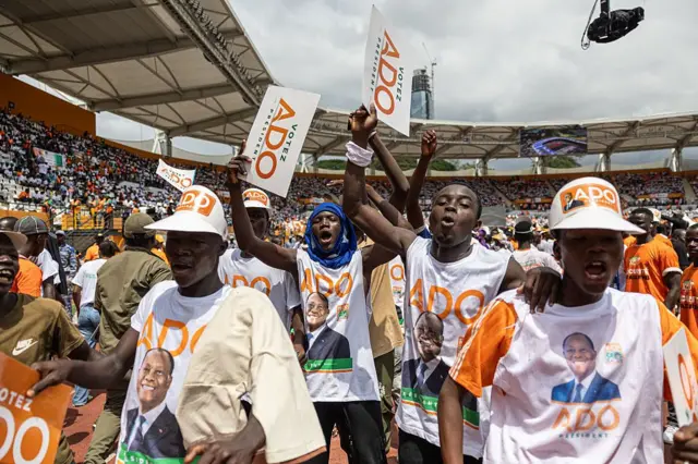 Des partisans du président ivoirien et candidat à la présidentielle du Rassemblement des houphouétistes pour la démocratie et la paix (RHDP) Alassane Ouattara chantent et dansent au stade Félix Houphouët-Boigny à Abidjan le 18 octobre 2025, avant la prochaine élection présidentielle.