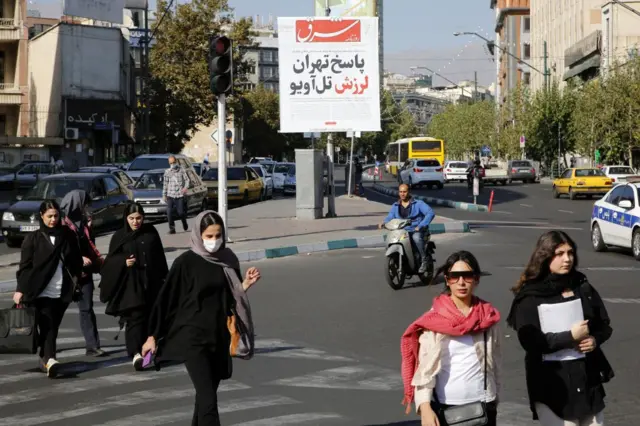 بیلبوردی از روزنامه شرق در یک خیابان و عابران و خودروها