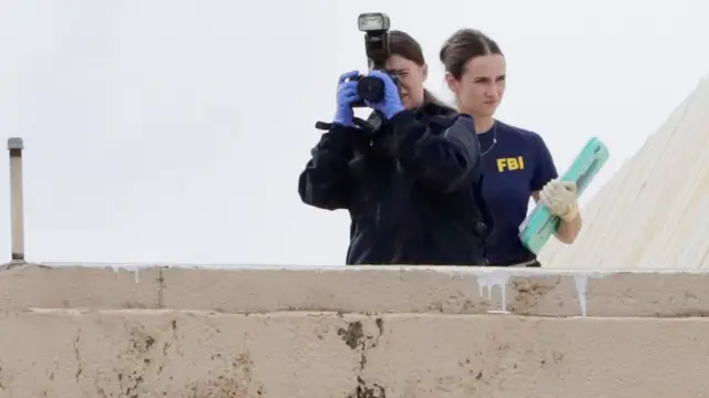 Miembros del FBI investigan desde la azotea del edificio 1120 Empire Central Place, cerca de la escena donde un atacante abrió fuego.