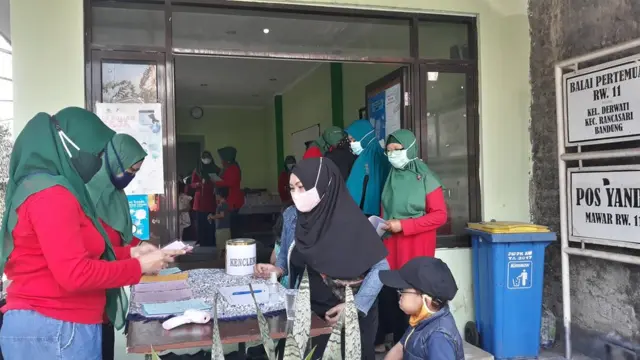 Seorang ibu membawa anaknya berkunjung ke Posyandu Mawar di Kelurahan Derwati, Bandung.