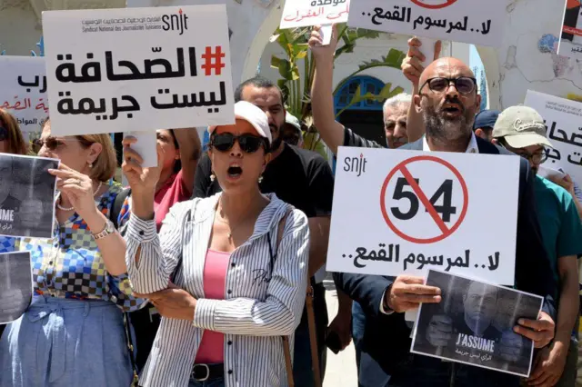 صحفيون تونسيون يحملون لافتات كُتب عليها "لا لمرسوم القمع" خلال مظاهرة بتونس يوم 27 مايو/ أيار 2024. 