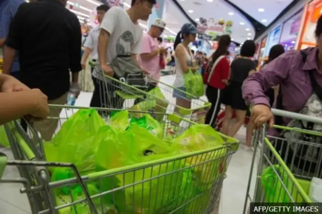 คนเข็นรถเข็นที่มีถุงพลาสติก