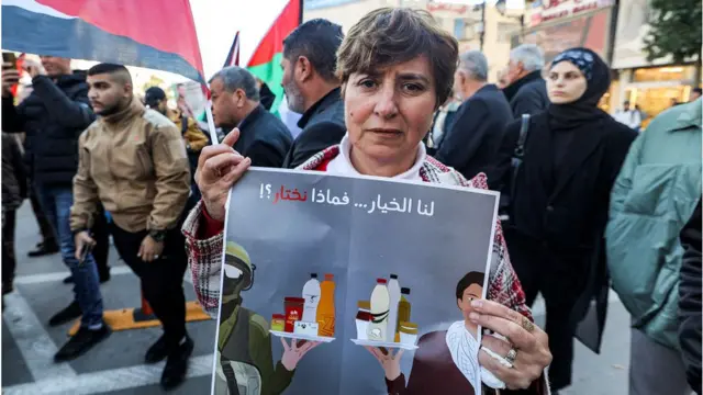 Seorang perempuan membentangkan poster berisi seruan boikot produk-produk Israel dalam demonstrasi di Ramallah, Tepi Barat, Desember 2023 lalu.