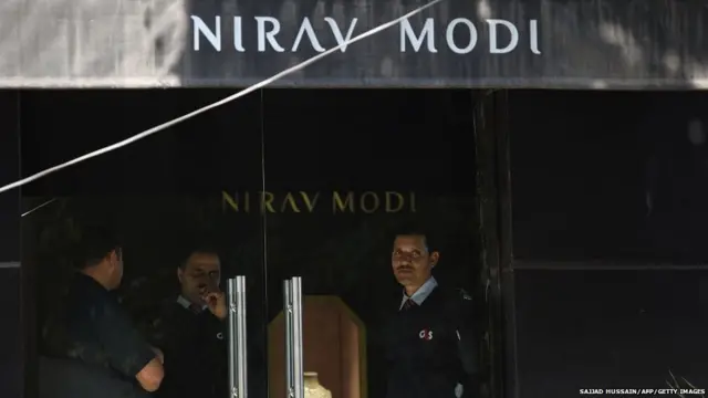 Indian security guards stand at the entrance of a Nirav Modi jewellery showroom in New Delhi on February 15, 2018.