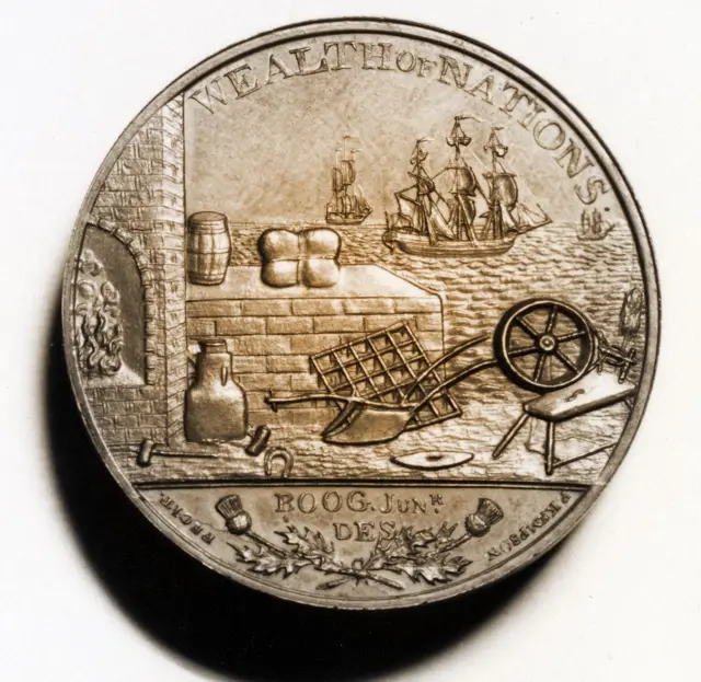 Moneda que dice "Riqueza de Naciones" y muestra barcos en el mar y productos en tierra. 