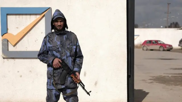 A security officer stands in front of the High National Election Commission building in Benghazi