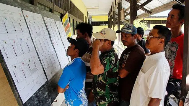 Warga melihat daftar calon anggota legislatif pada pemilu 9 April 2014 di desa Temajuk, Kalimantan Barat.
