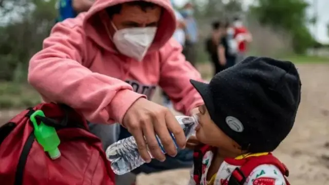 યુએસ-મેક્સિકો સરહદ પર ટેક્સાસના ડેલ રિયોમાં પ્રવાસી બાળક સાથે. આ તસવીર 16 મે, 2021ના દિવસની છે.