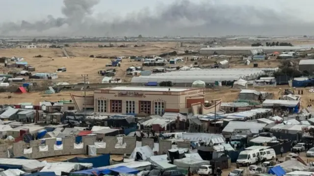 الدخان يتصاعد خلال عملية برية إسرائيلية في خان يونس، كما يظهر من مخيم للنازحين الفلسطينيين في رفح